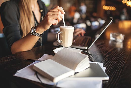 Woman working on a laptop in a coffee shop